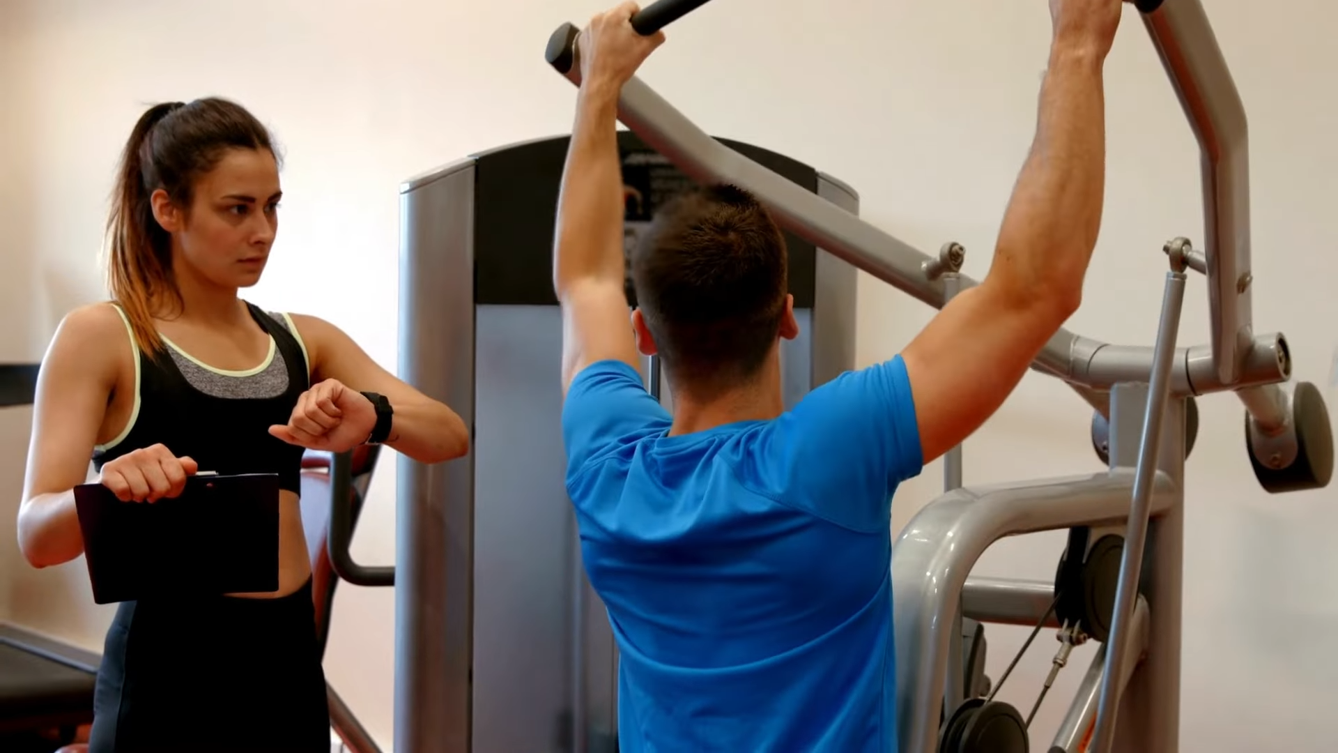 A Fitness Professional Oversees a Client's Workout Using Improper Technique and Timing, Highlighting Common Training Mistakes