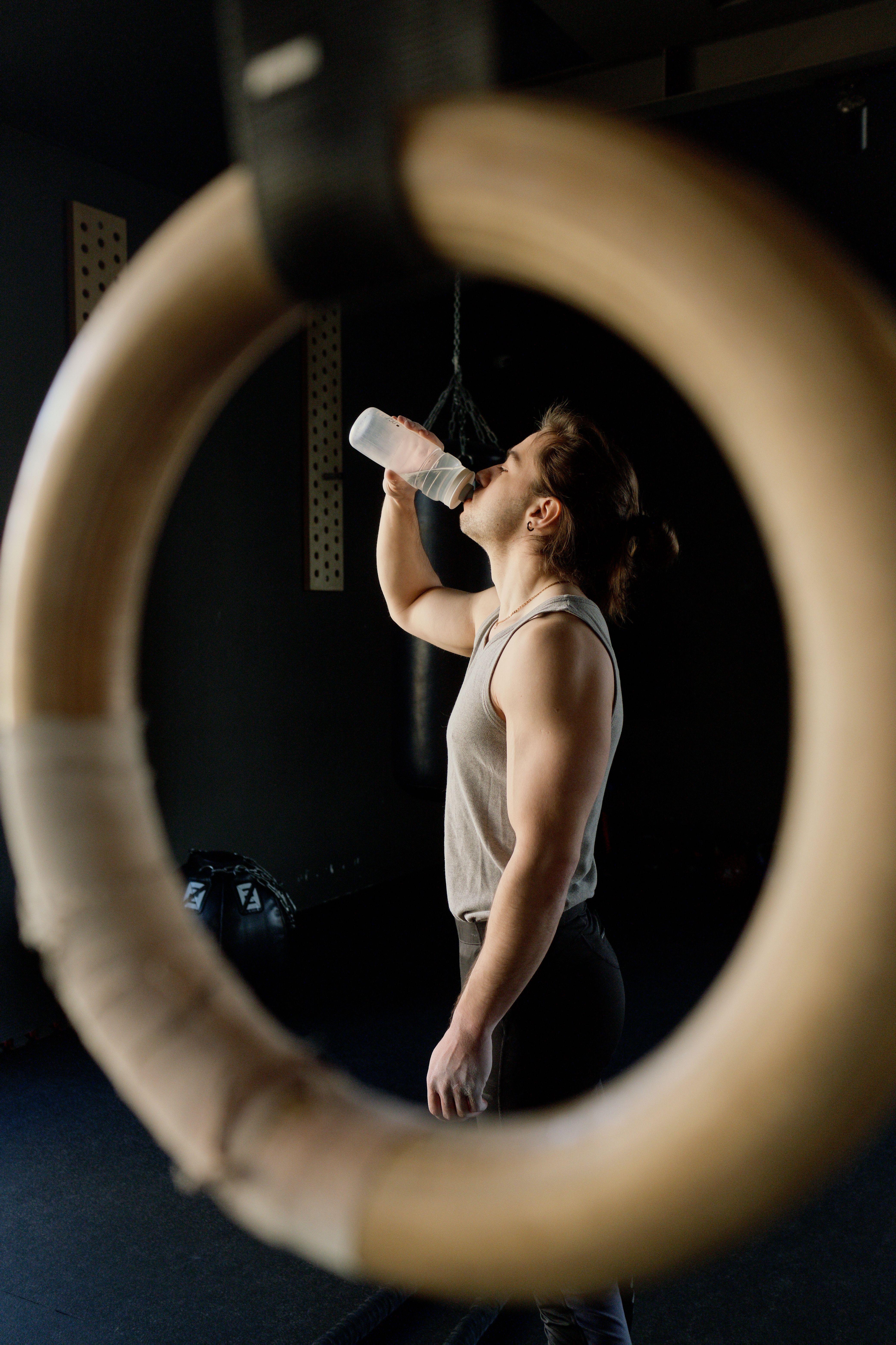 Man drinking water in the gym after workout for hydration