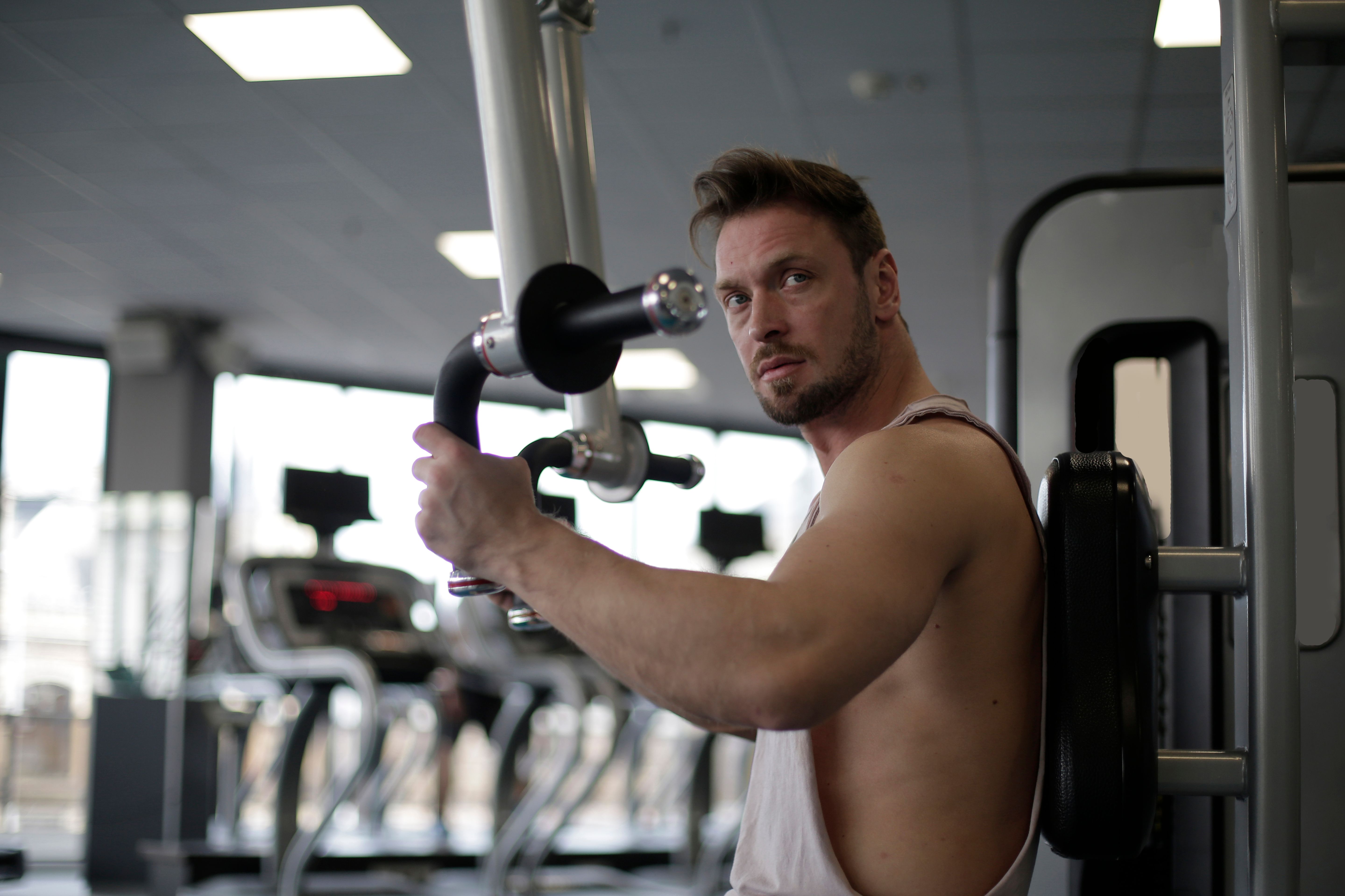 Focused man performing strength training exercises in the gym